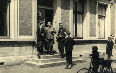 97650 Afbeelding van een overleg tussen een Duitse militair, staand in de deuropening van het Bureau van de ...